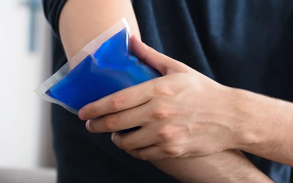 Person holding cold compress against arm