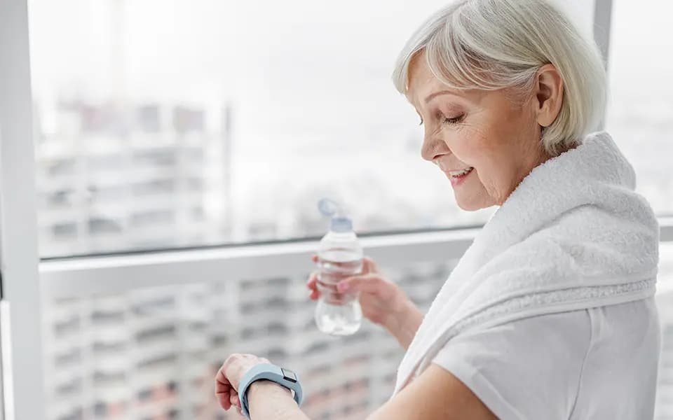 Senior woman using smartwatch after training