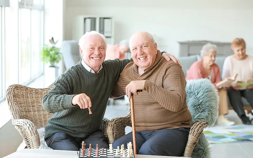 Senior men playing chess in nursing home