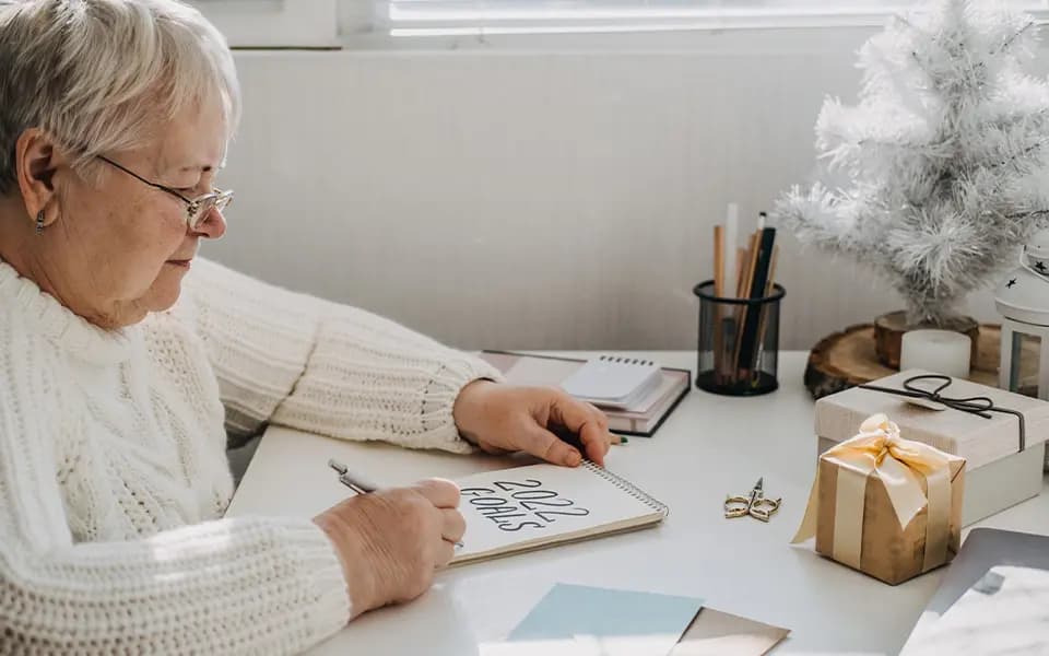 Woman writing 2022 goals on paper