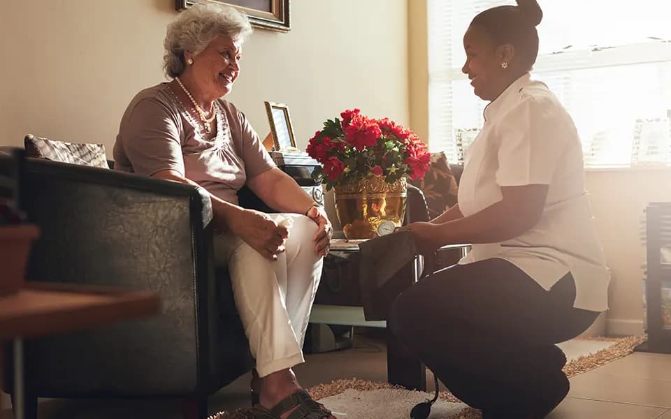 Employee kneeling to patients eye level and smiling