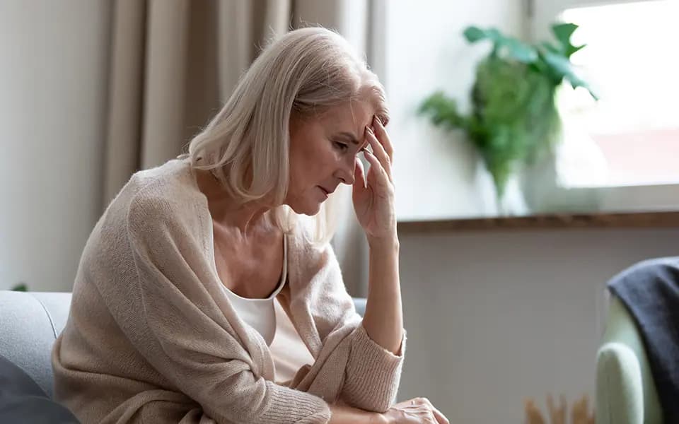 Woman holding forehead in frustration