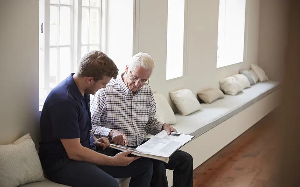 Employee helping patient read a book