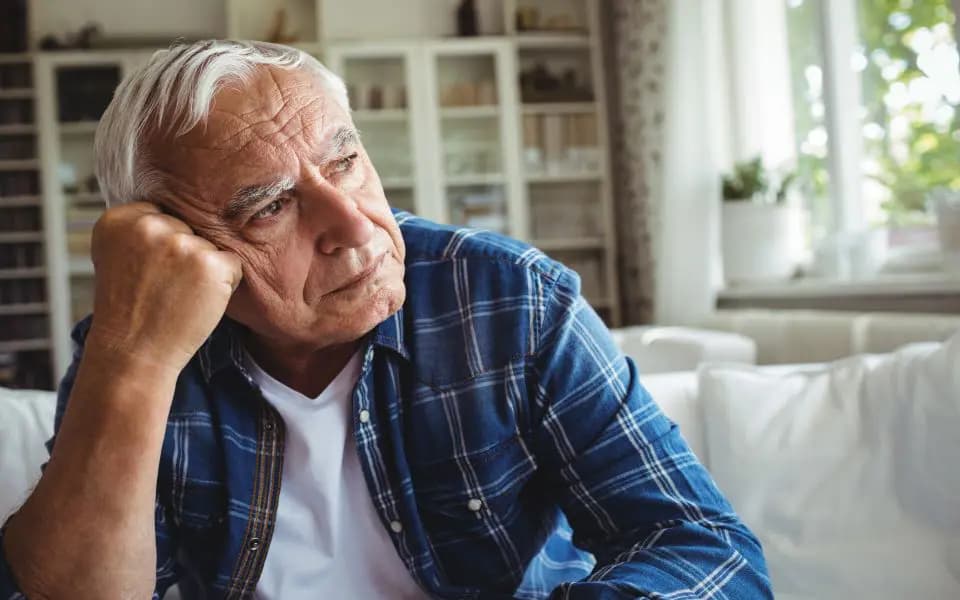 Worried senior man sitting on a sofa