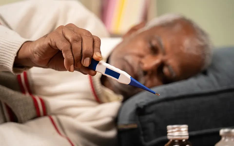 Selective focus on thermometer, sick bed ridden old man seeing temperature on thermometer