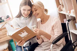senior woman and daughter looking through memory book