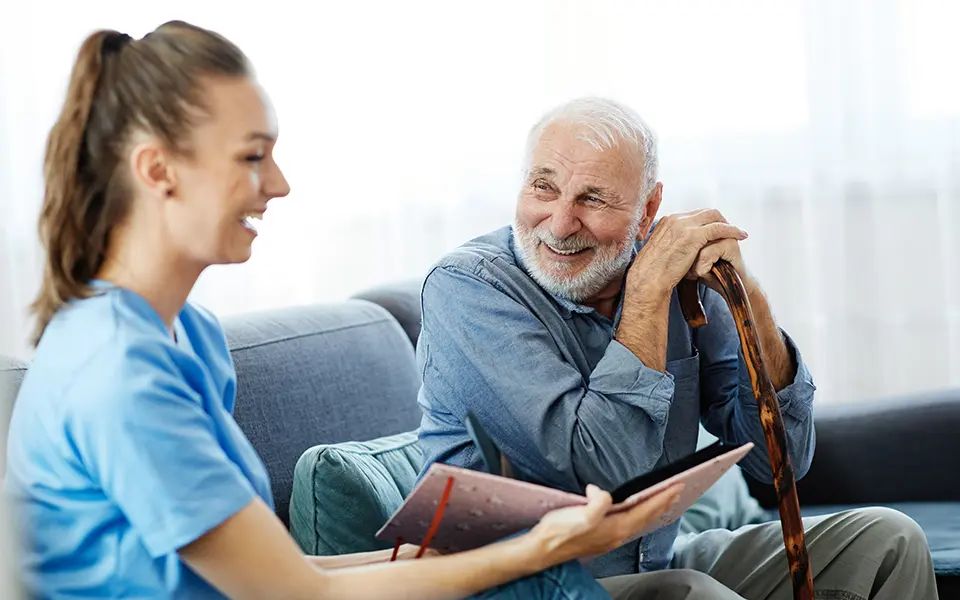 senior male smiling with laughing nurse