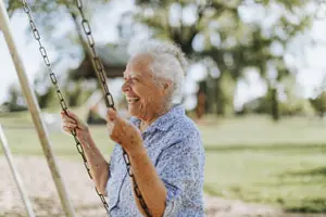 senior swinging at park