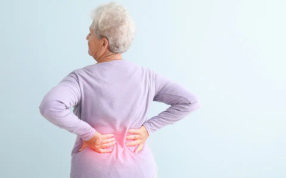 Elderly woman holding back in pain