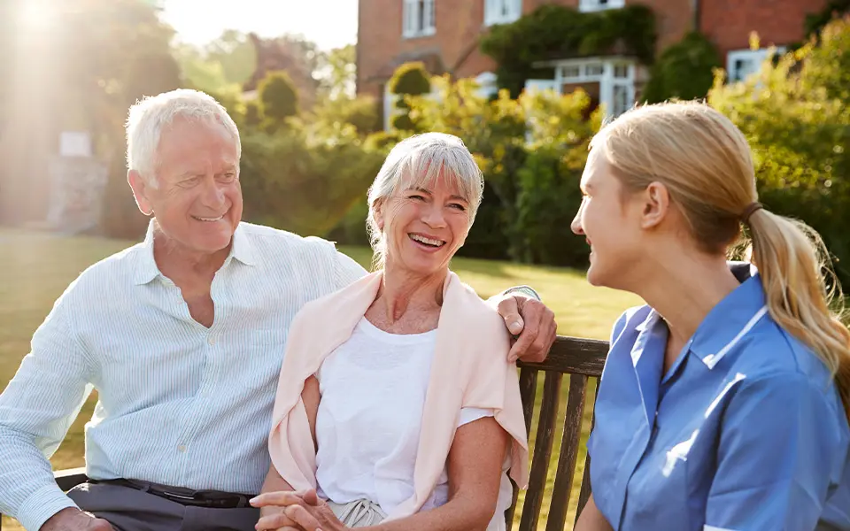 Senior couple talking to a nurse at an assisted living facility