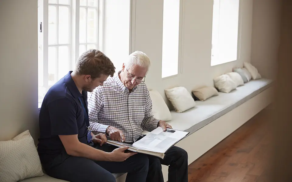 Employee helping patient read a book