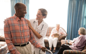 Smiling senior man with walker looking at female doctor against