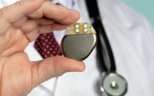 Male hand hold cardiac pacemaker. Embassy Healthcare offers therapy and rehabilitation services for patients with pacemakers. Click to learn more.